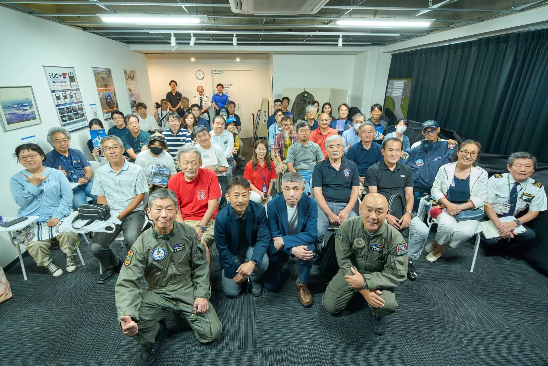 イベント参加者とパイロット姿のスタッフの集合写真