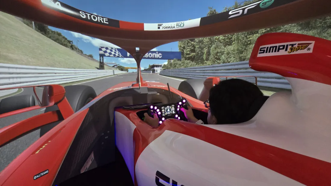 フォーミュラカー型のレーシングシミュレーターを運転している様子